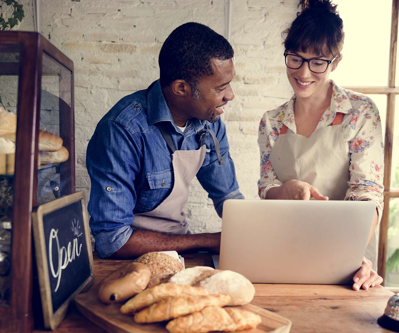Self-employed bakery owner researches 1099 mortgage on laptop