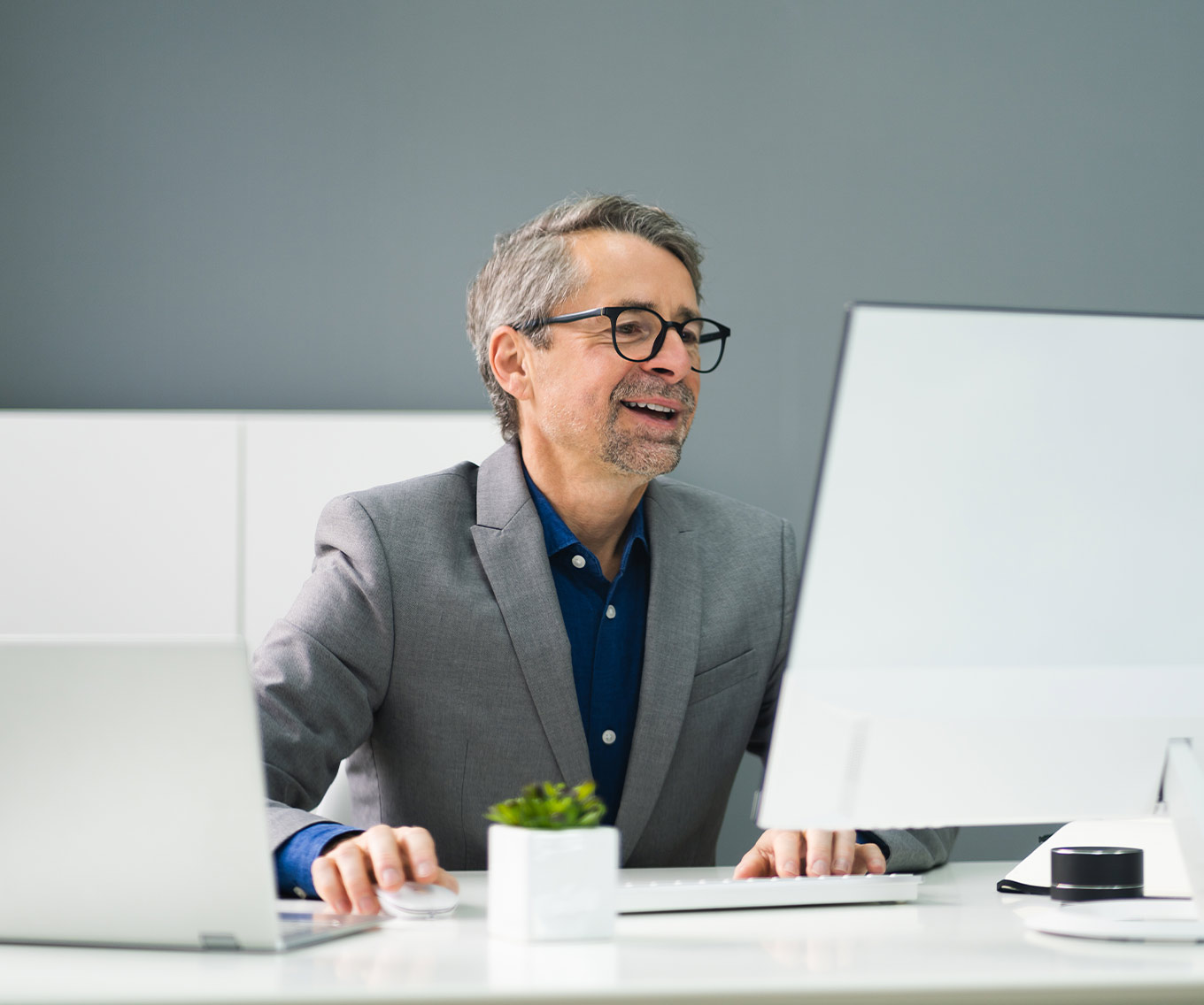 Man sitting at desk identifies a scam on his computer.